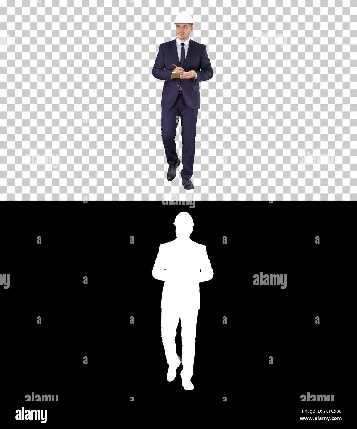 Engineer in suit and helmet walking and writing notes in notepad Stock Photo