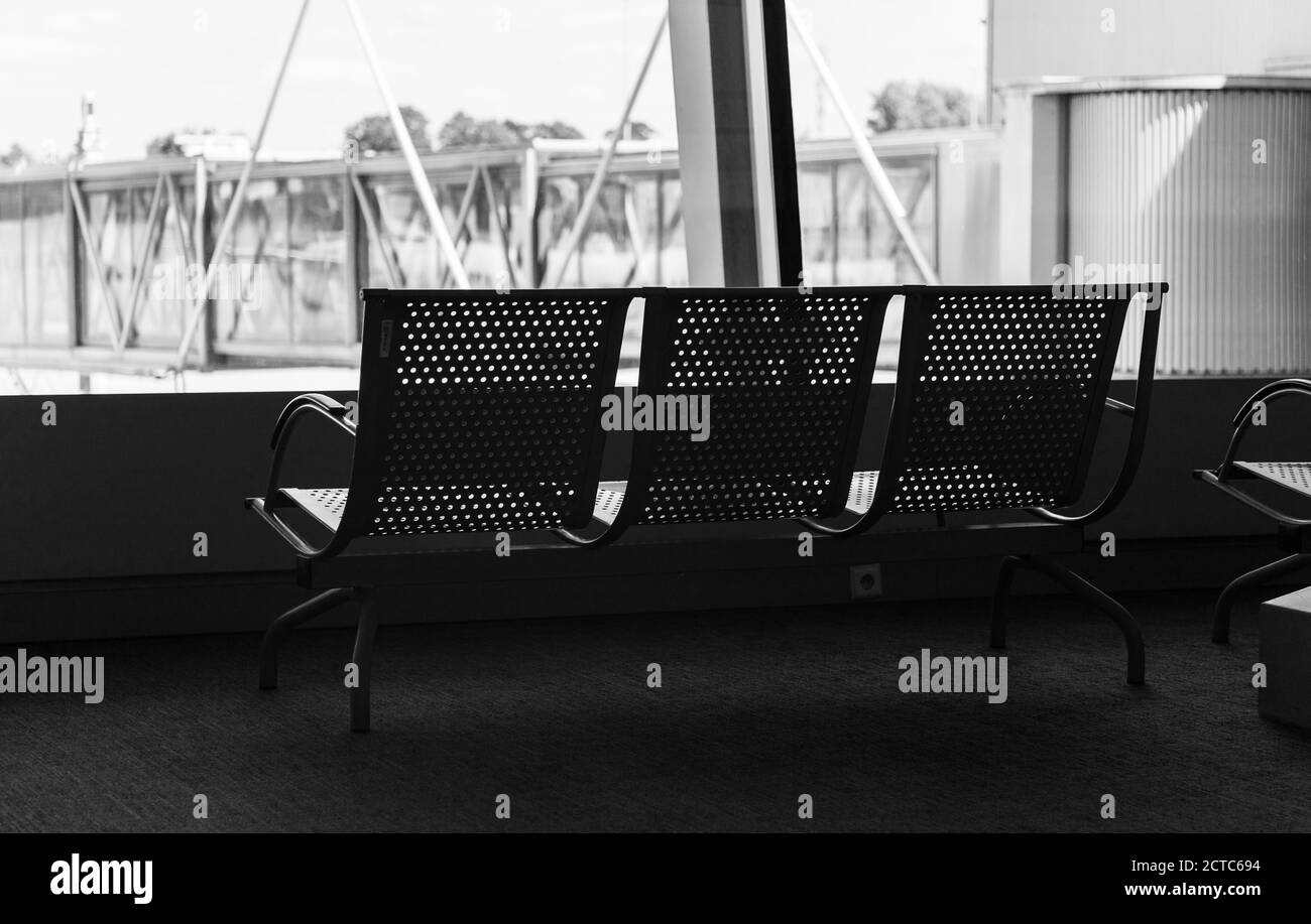 A black and white picture of a set of benches in the airport of the Warsaw Chopin Airport. Stock Photo