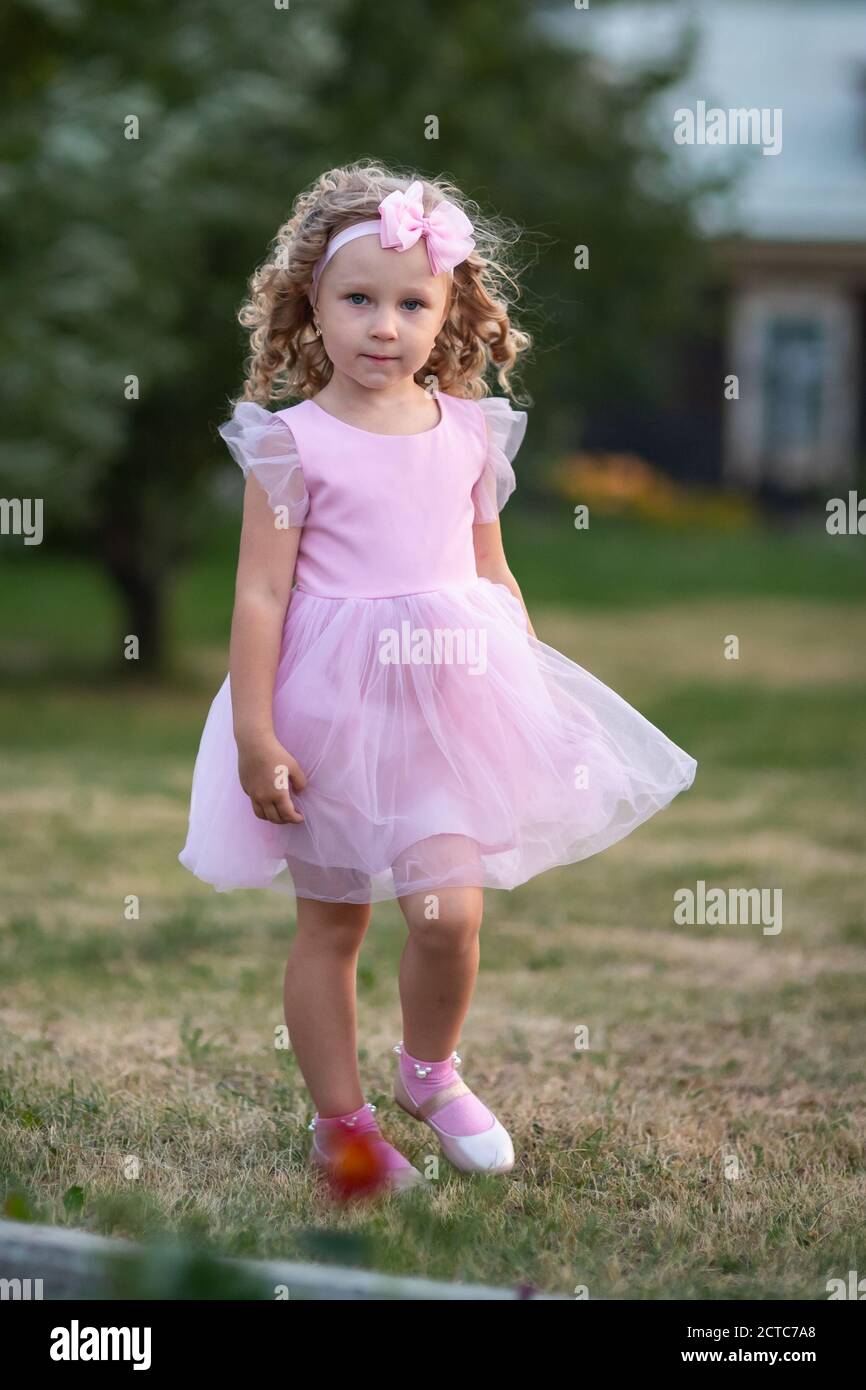 Portrait of little girl in pink dress on the street Stock Photo