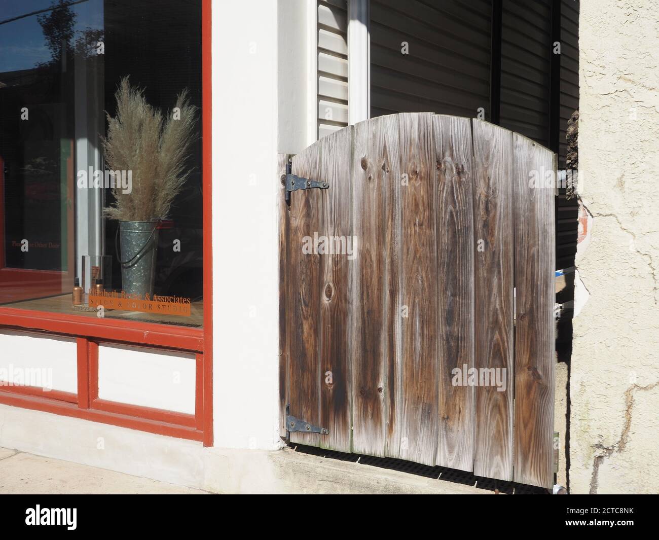 Streetscene in a small village with a gate and store window. Stock Photo