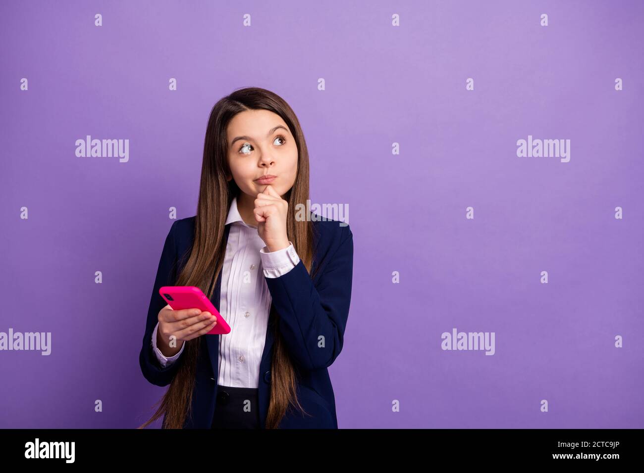 Portrait of her she nice brainy small little minded long-haired doubtful girl using gadget thinking copy space creating strategy isolated bright vivid Stock Photo