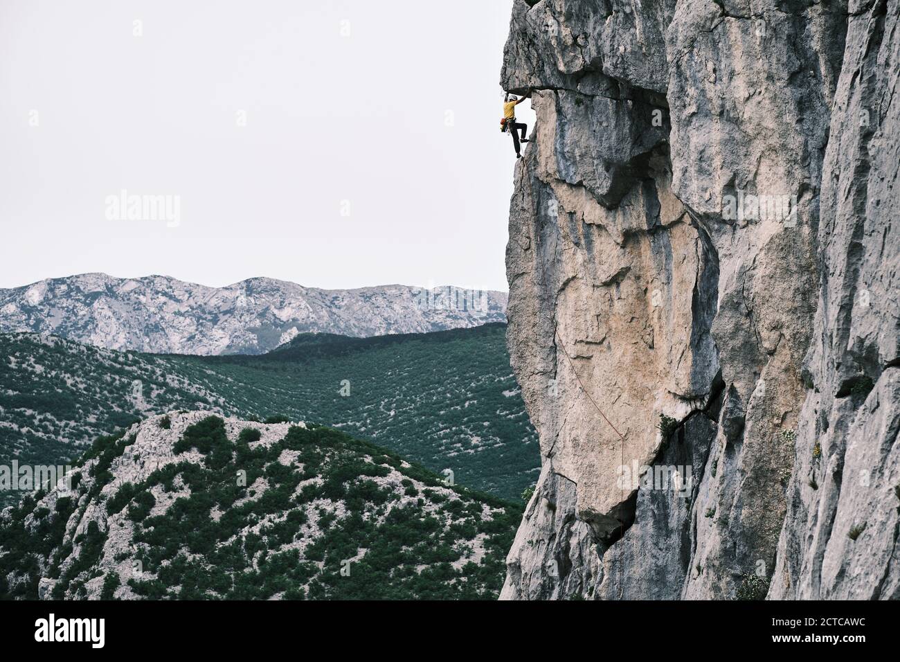 Male climber reaching summit of Anica kuk in Paklenica National Park in Croatia. Stock Photo