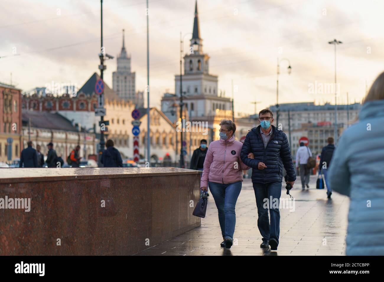 Moscow, Russia - September 10, 2020: Moscow cityscape at sunset after rain.  Pair of middle aged man and woman put on protective face mask. Coronaviru Stock Photo