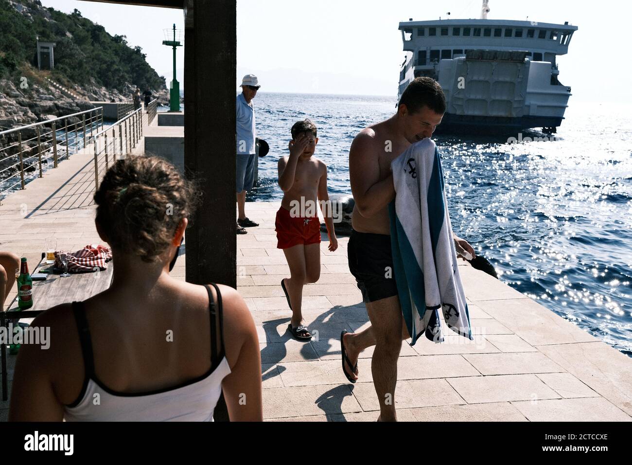 Tourists waiting for a ferry boat in a Croatian port. Stock Photo
