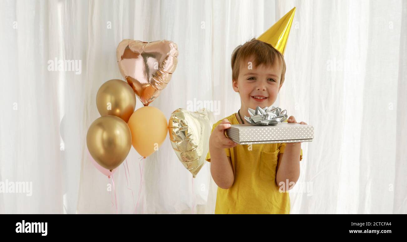 Funny kid in yellow t-shirt holds paper present box closeup Stock Photo