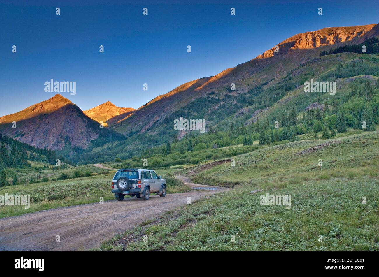 4WD vehicle on Alpine Loop near Cinnamon Pass, Cinnamon Mtn in distance, sunrise, San Juan Mountains, Colorado, USA Stock Photo