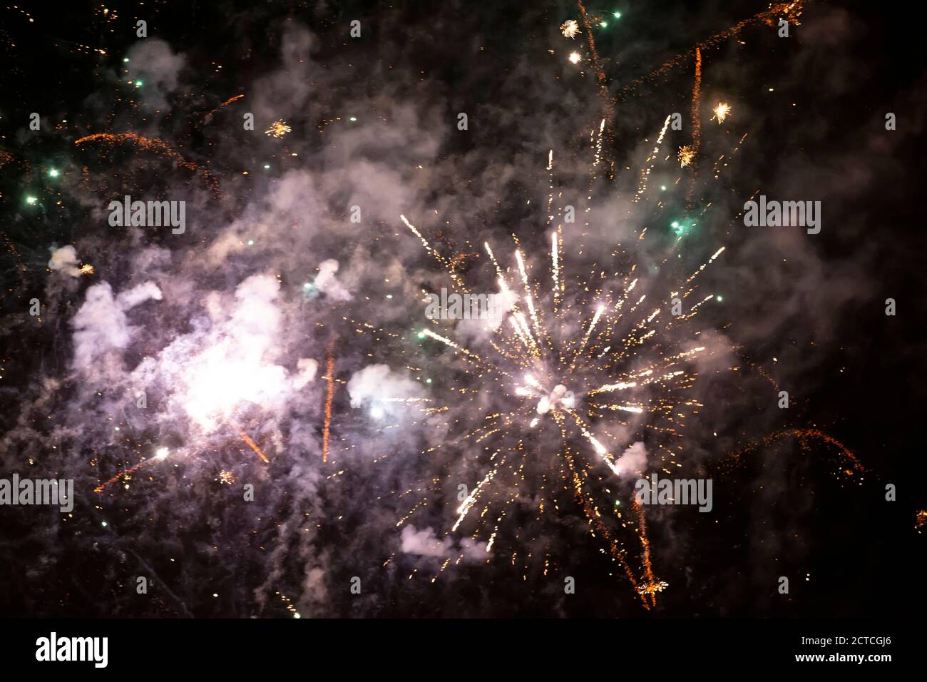 Festive background of golden fireworks and white smoke. Stock Photo