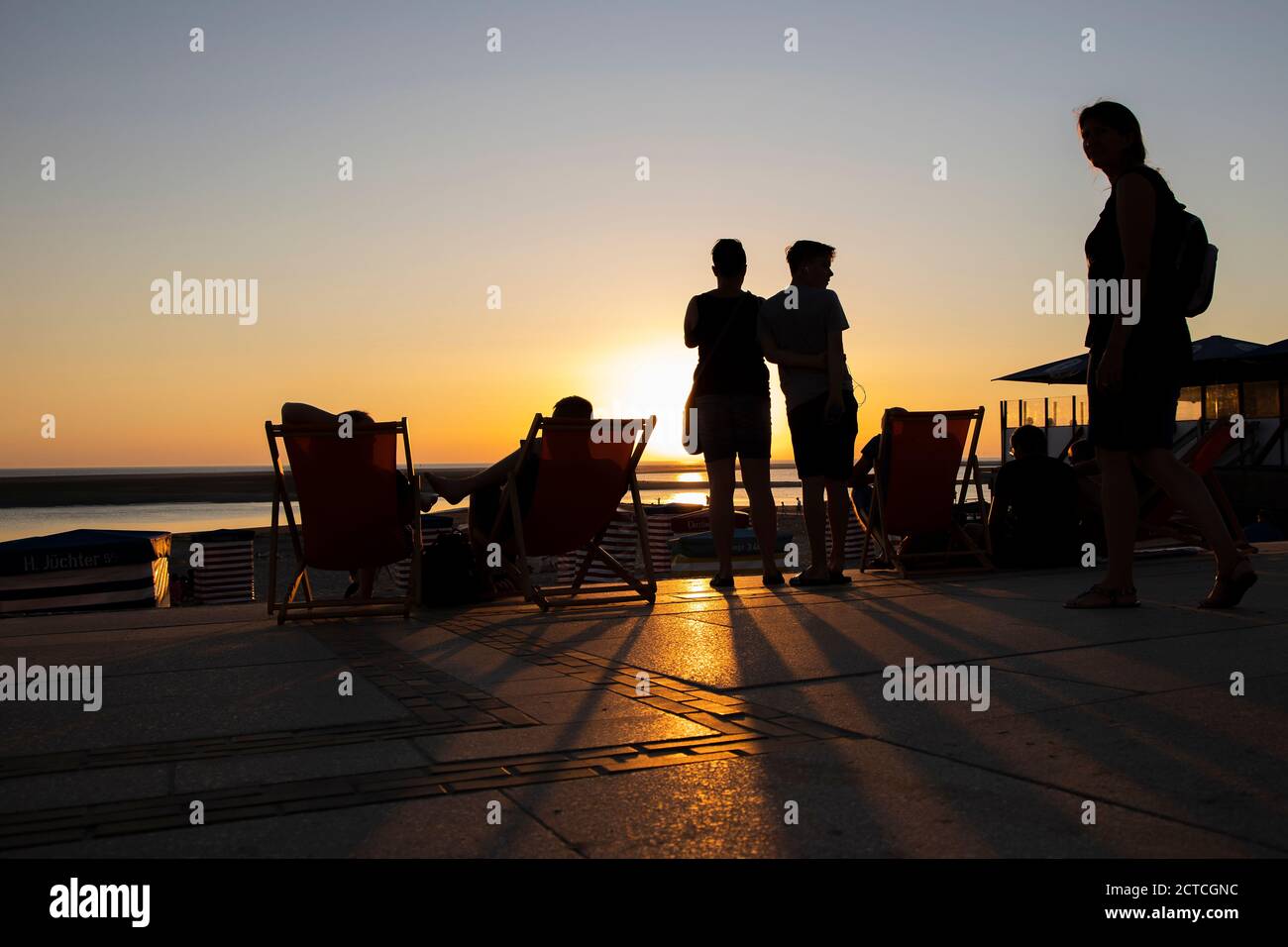 Silhouette of people on promenade watching sunset on  Borkum Island, Frisia, Lower Saxony, Germany, Europe. Stock Photo