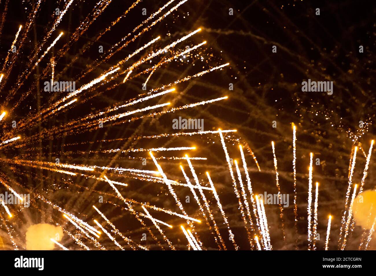 Festive background golden rays of fireworks on a dark background. Stock Photo