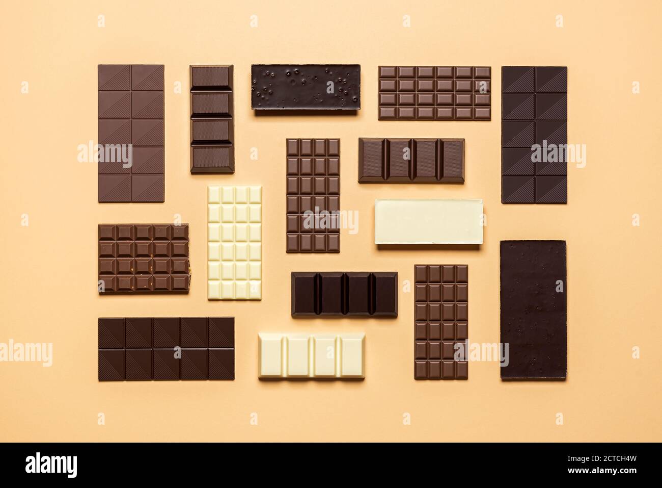 Chocolate bar assortment isolated on a beige background. Top view of