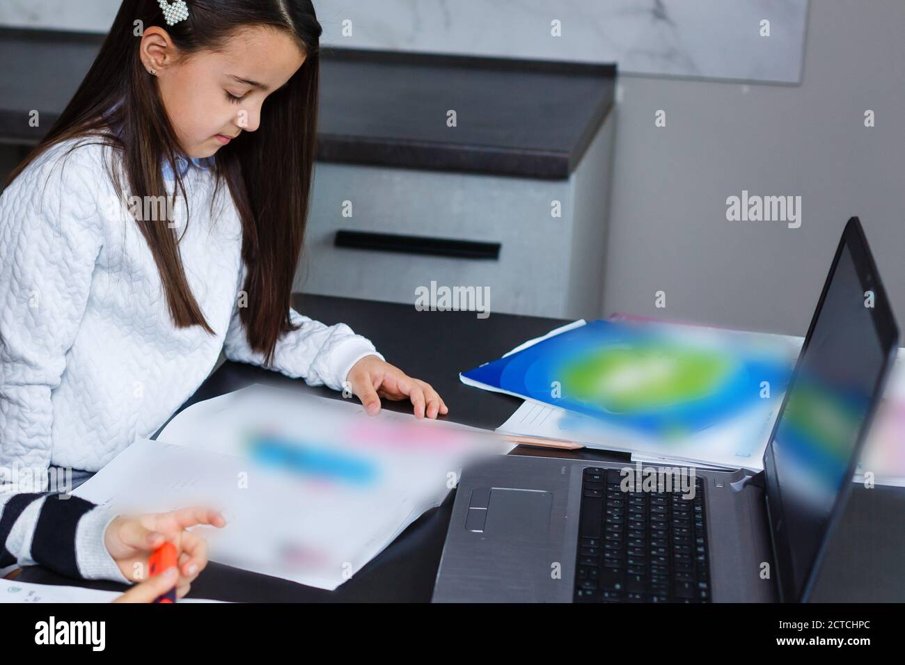 Little girl studying online using her laptop at home Stock Photo - Alamy