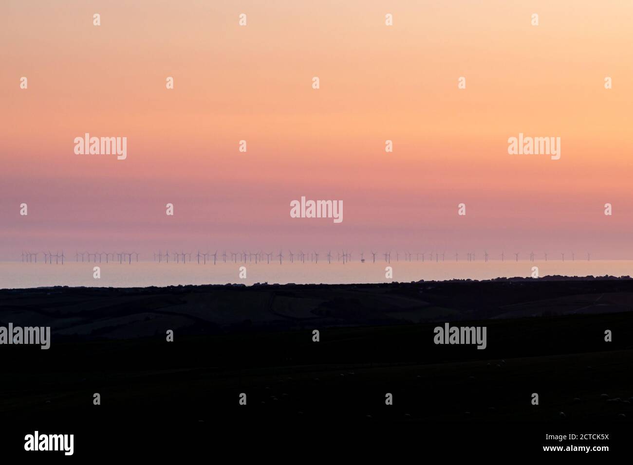 Looking out over the ocean at sunset, from Firle Beacon in Sussex Stock Photo