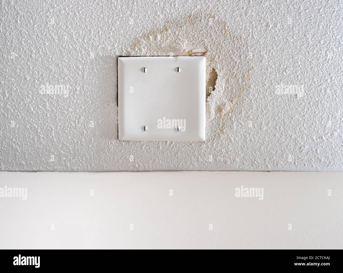 Water damage on popcorn ceiling. Saturated yellow water stain and