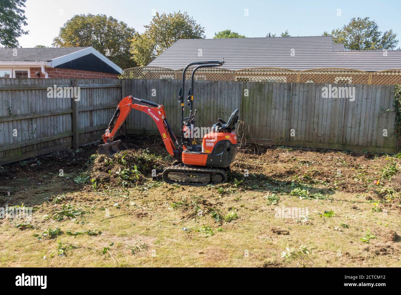 Mini digger clearing garden for remaking Stock Photo