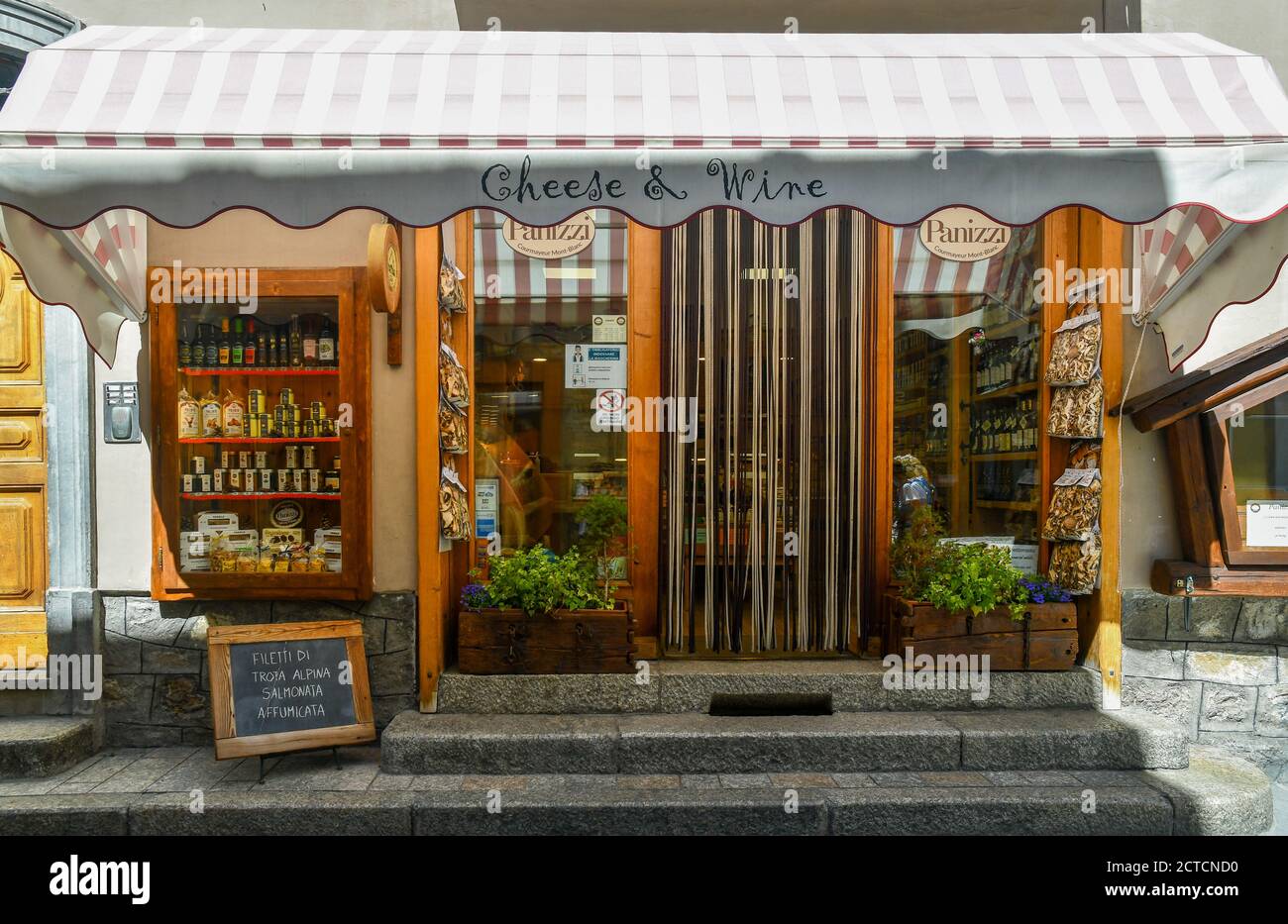 Exterior of a grocery store selling typical Valdostan food, cheeses and wines in the centre of the mountain town, Courmayeur, Aosta Valley, Italy Stock Photo
