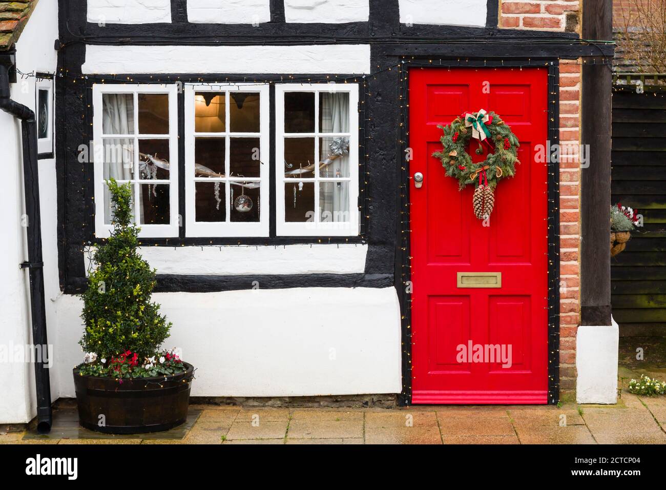 WINSLOW, UK - December 26, 2019. Christmas wreath and decorations outside heritage home, cottage house in UK, winter street scene Stock Photo