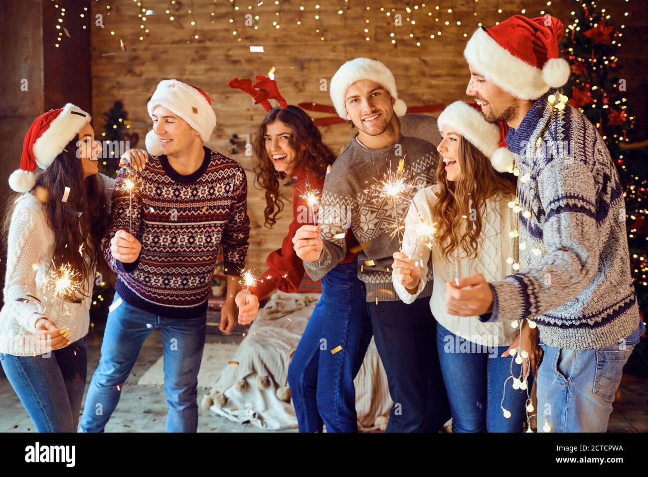 Happy friends with sparklers at home for Christmas Stock Photo