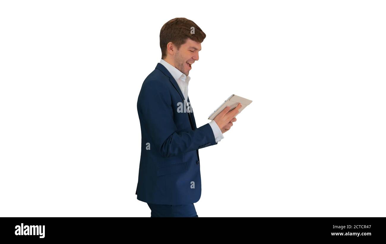 Smiling businessman using digital tablet while walking on white Stock Photo