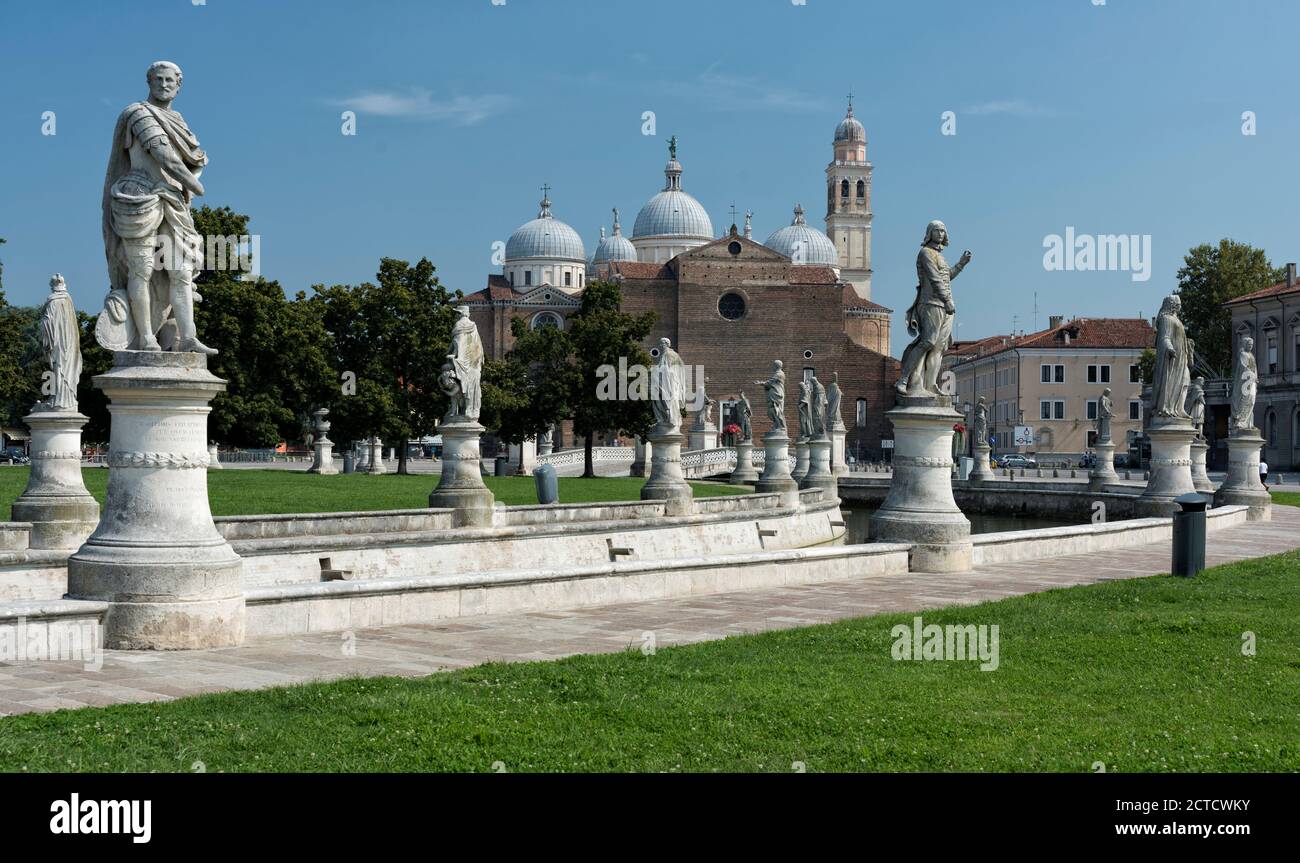 Prato della Valle, its canal, with many impressive classical statues on plinths. The Basilica Santa Giustina in the background, Padova, Veneto, Italy. Stock Photo