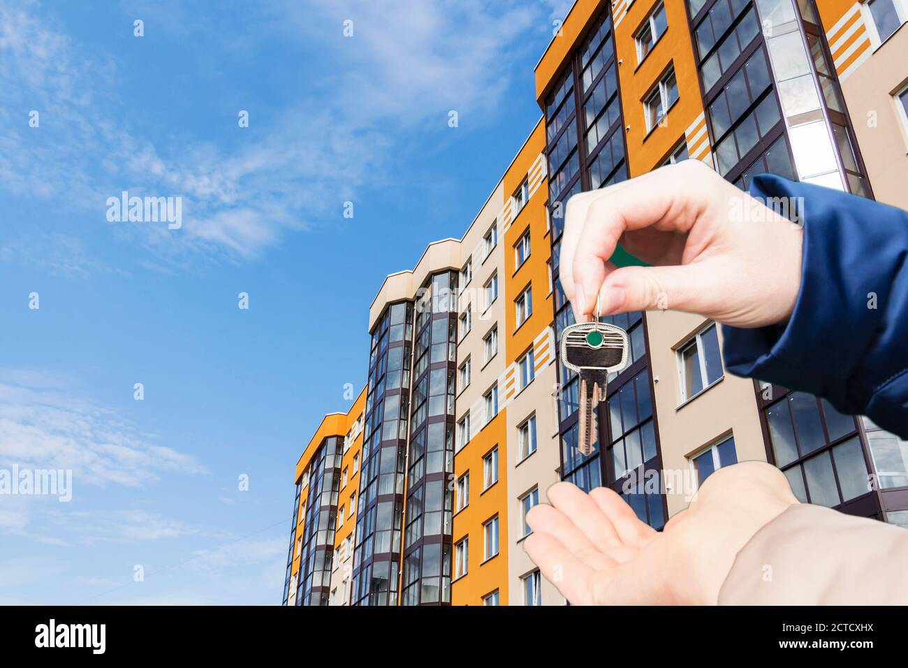 Hand with keys in the background apartment building Stock Photo Alamy