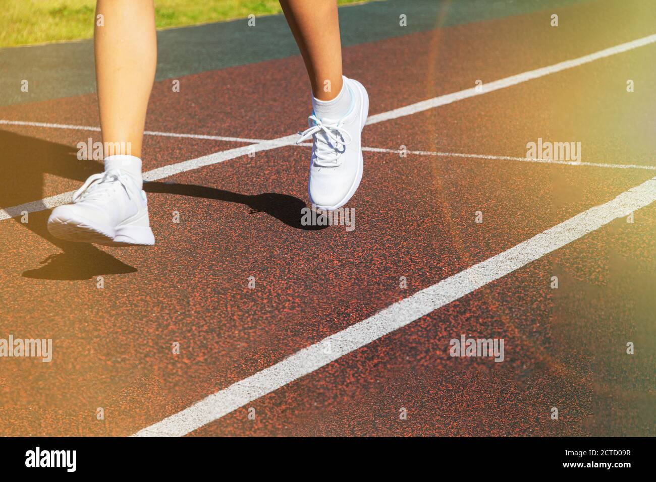 A runner's feet run along the road in closeup on their shoes. Running