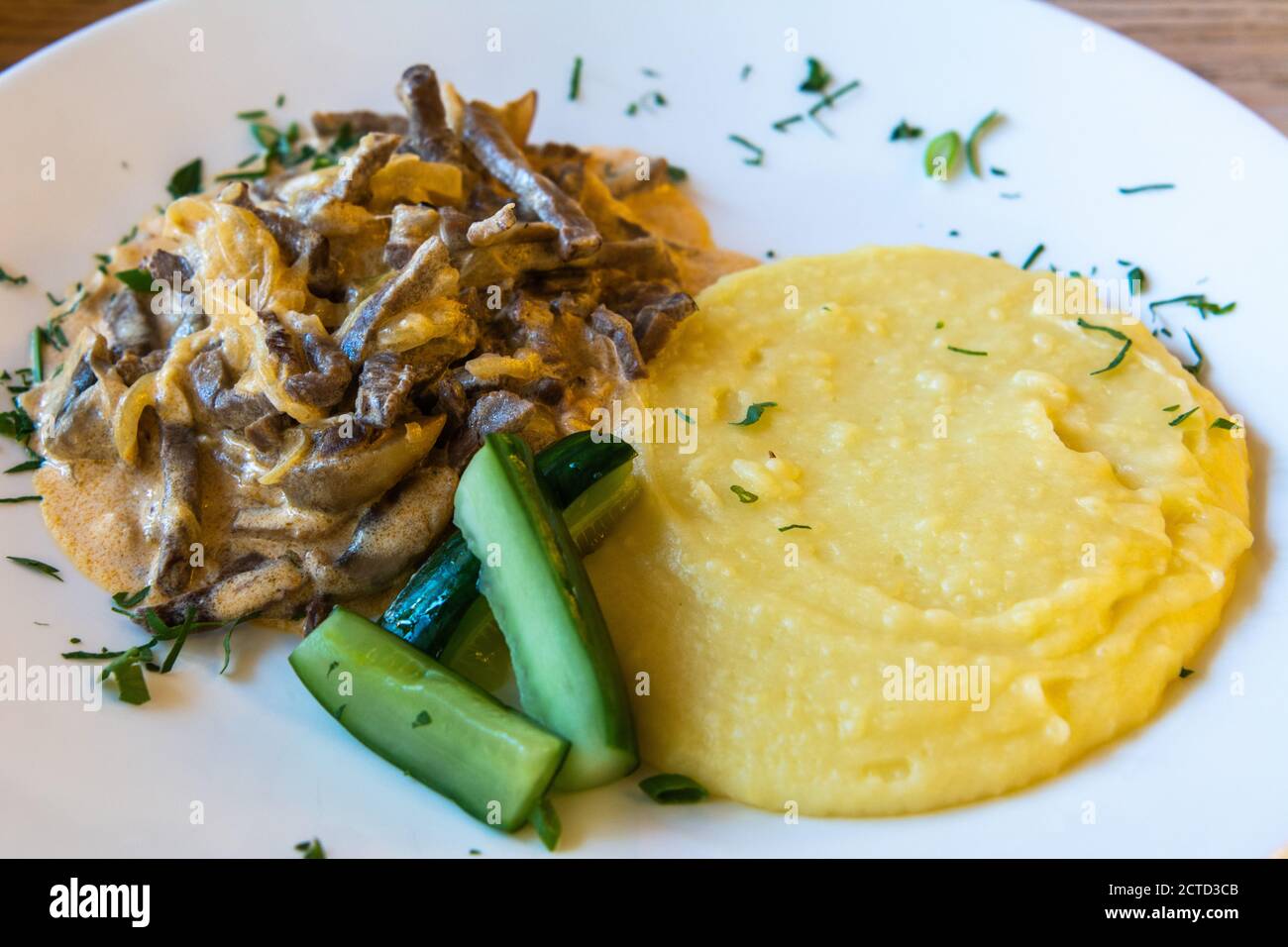 Plate of beef stroganoff with mashed potatoes and cucumber in Saint Petersburg, Russia Stock
