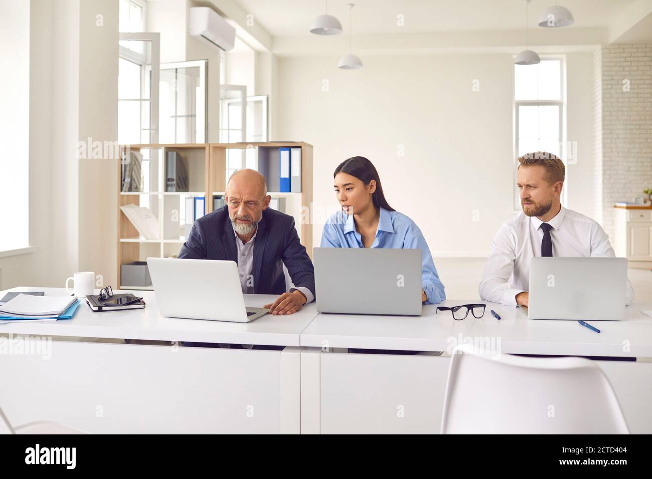 Team of tense businesspeople using computers, analyzing stock market data or having software problem Stock Photo