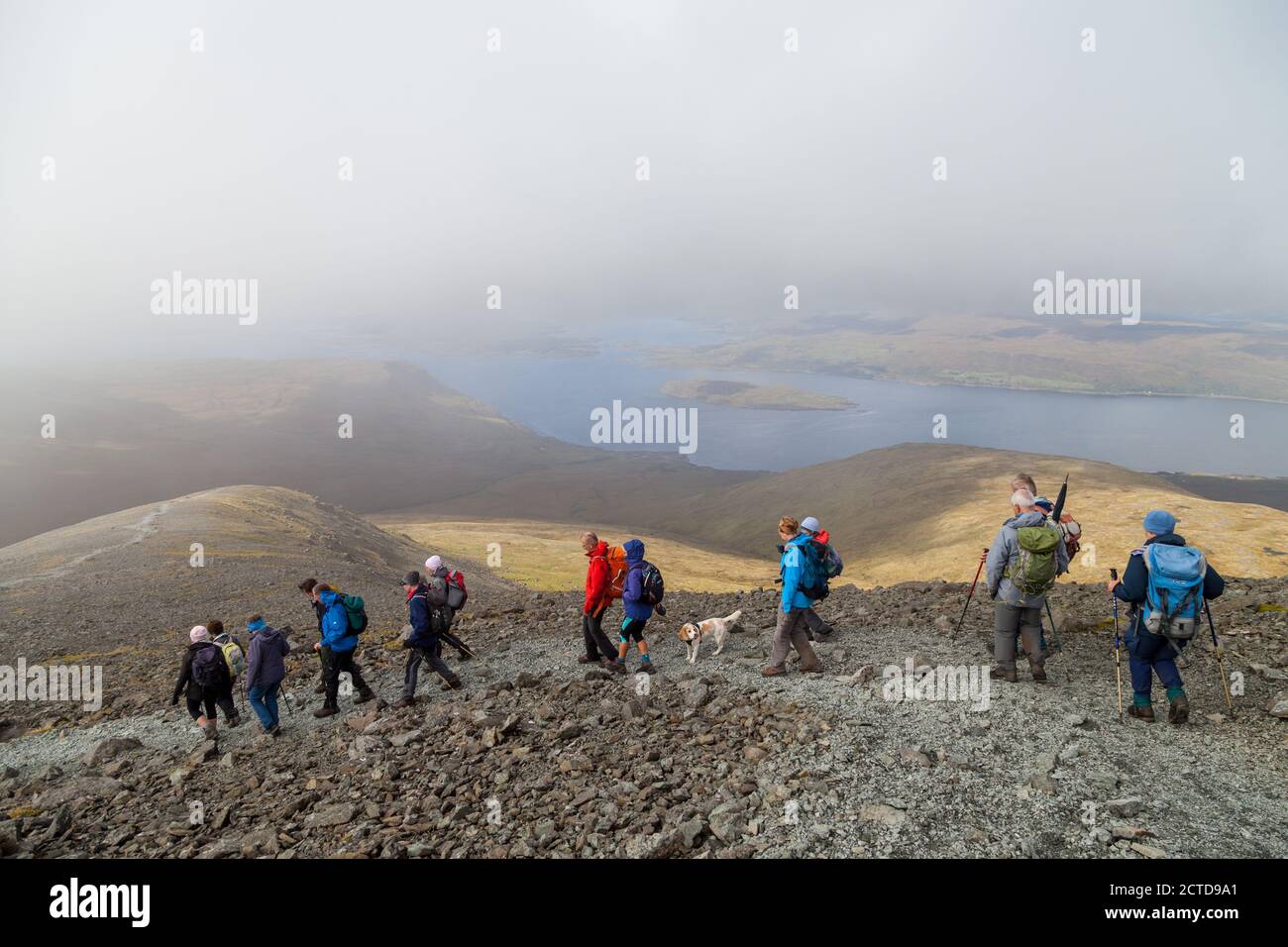 A walking group heading down from the Munro Ben More on the Island of Mull towards Loch na Keal Stock Photo