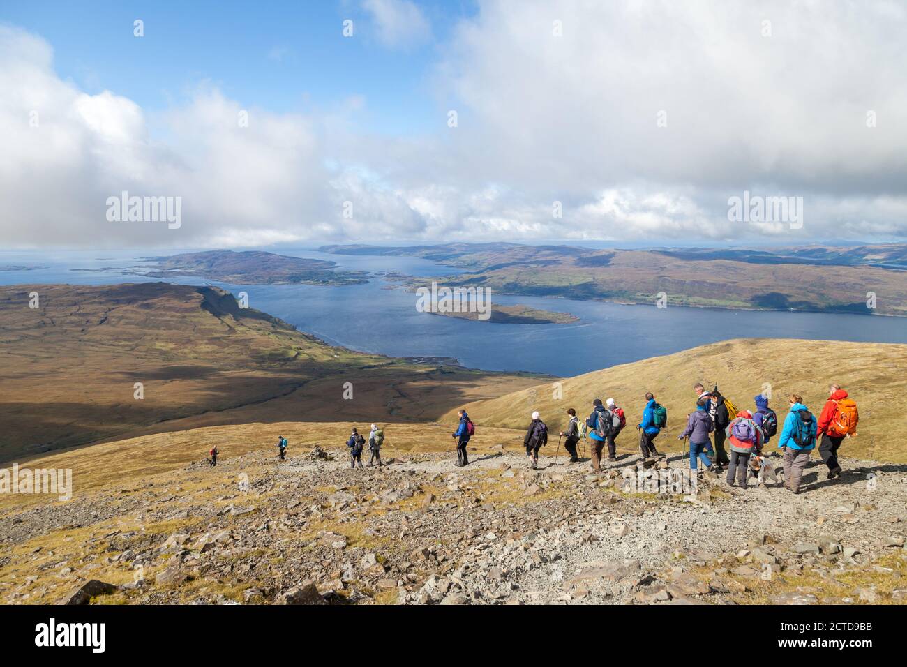 A walking group heading down from the Munro Ben More on the Island of Mull towards Loch na Keal Stock Photo