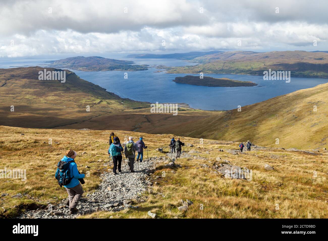 A walking group heading down from the Munro Ben More on the Island of Mull towards Loch na Keal Stock Photo