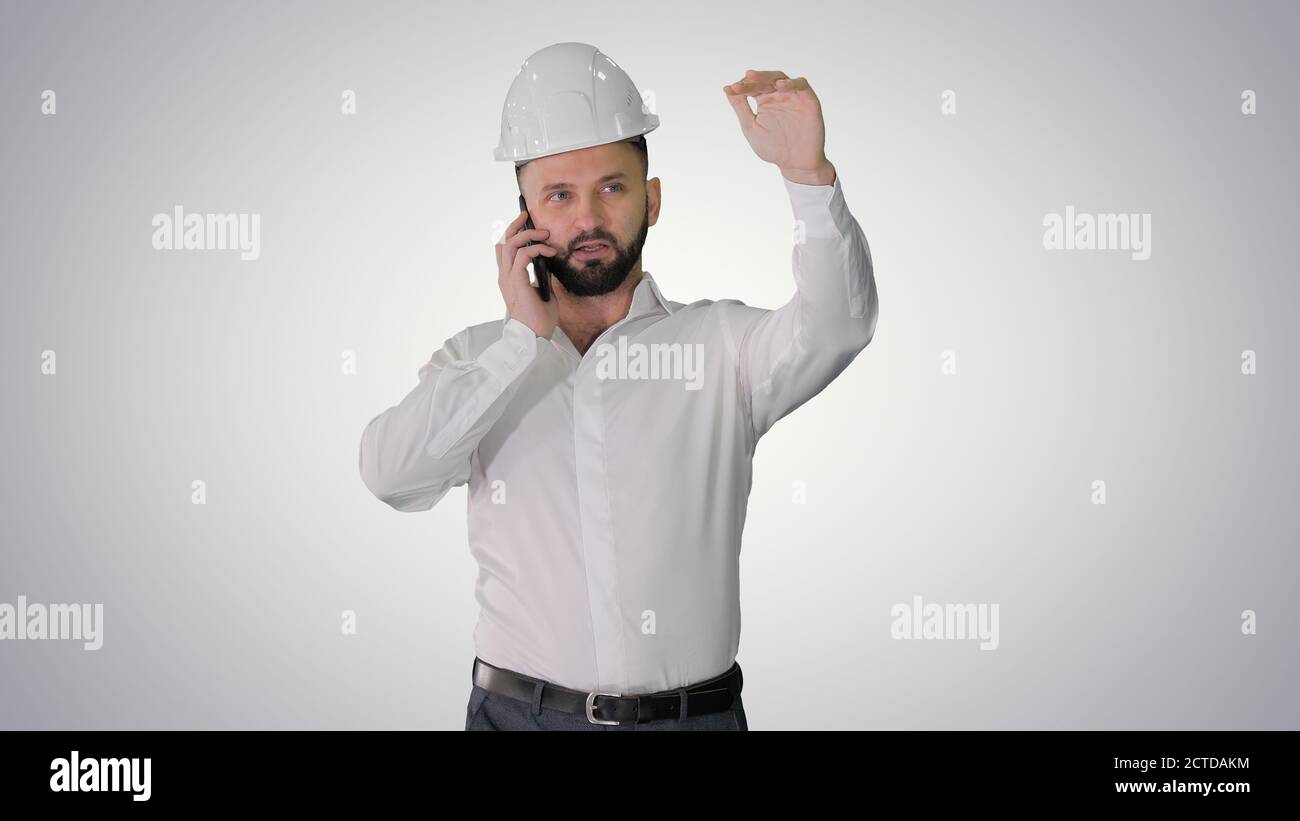 Architect talking by the phone while walking on gradient backgro Stock Photo