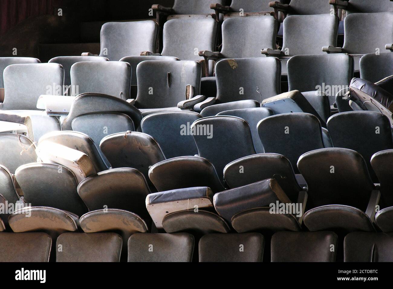 Pile of old worn seats awaiting renovation in historic vintage movie theater building. Stock Photo