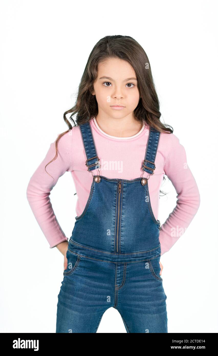 Kid fashion, casual style. Little girl pose in jeans overall, fashion. Child  with long brunette hair, beauty. Beauty, look, hairstyle. Childhood, youth,  punchy pastel trend Stock Photo - Alamy