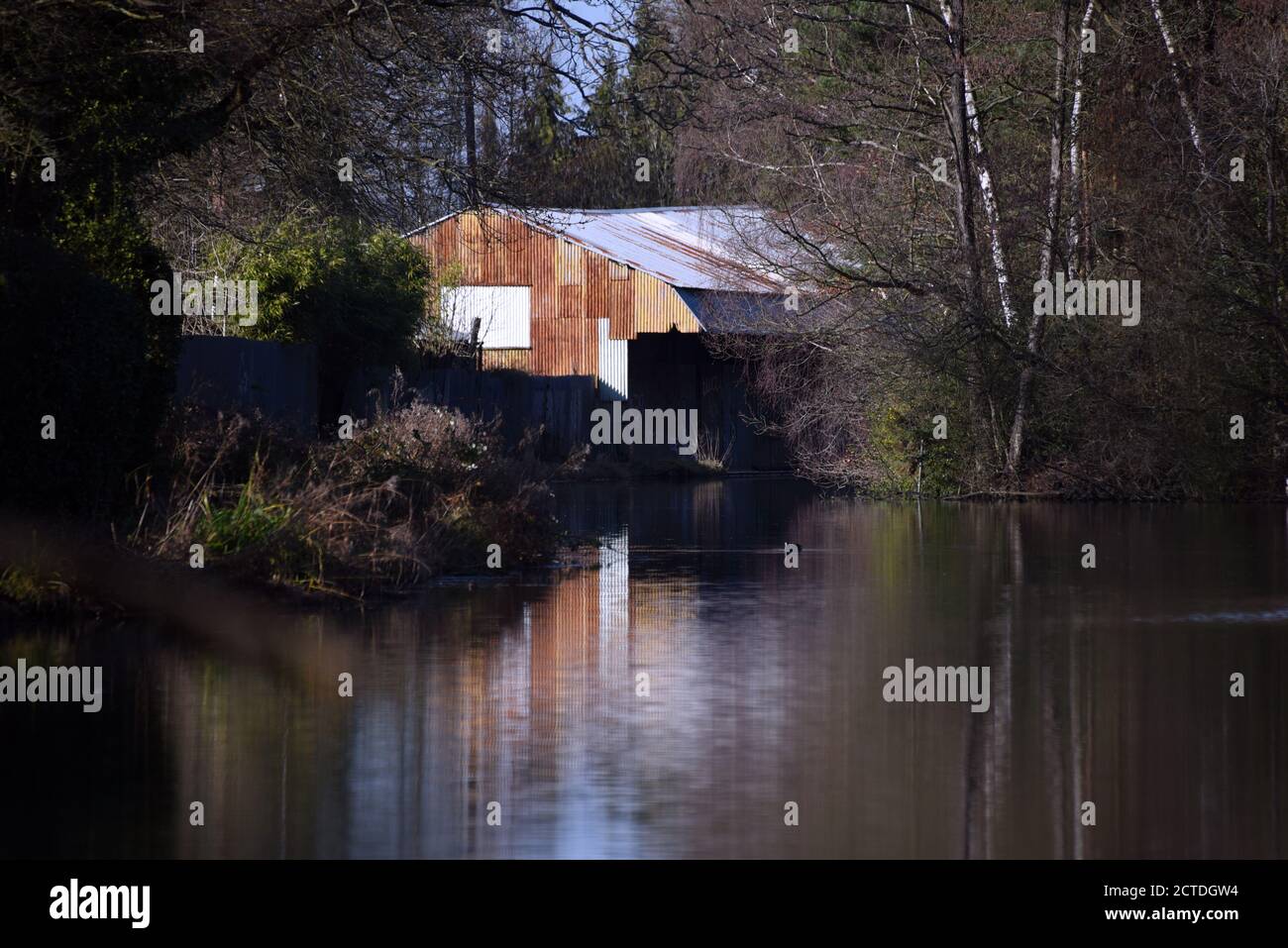 The rusty old boat house in Ash Vale is reflected in the still waters