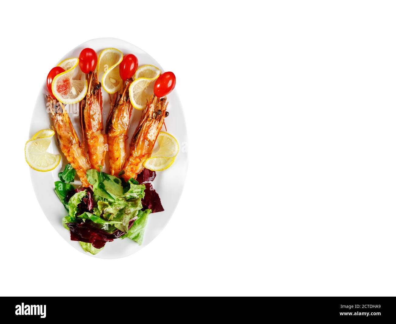 The head of the fish, mussels, greens and prawns are on a white plate. Restaurant service. Space for text Stock Photo