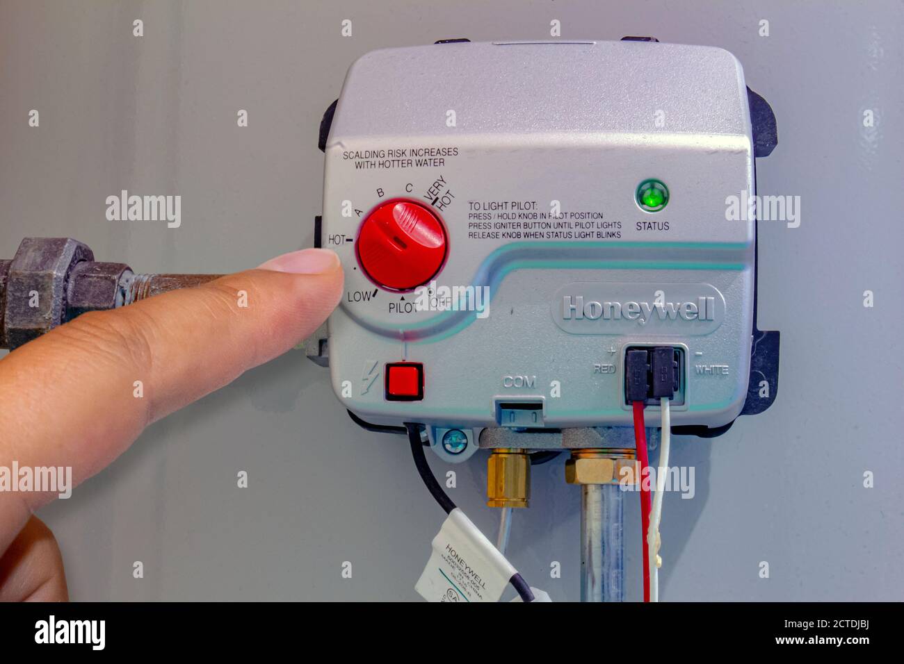 Calgary, Alberta, Canada. Sep 22, 2020. A person adjusting a Honeywell Gas control valve, residential gas water heater. Boiler Heating system. Stock Photo