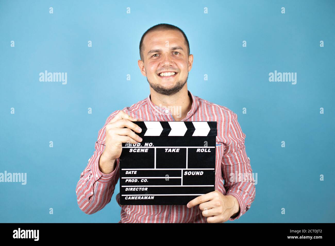 Russian business man over blue background holding clapperboard very happy having fun Stock Photo