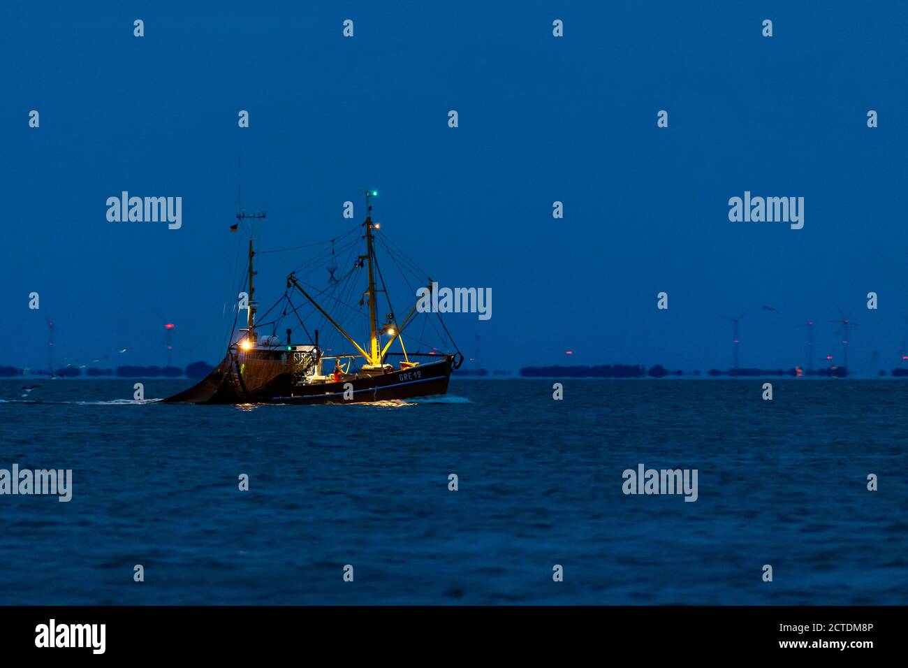 Shrimp boat fishing at night in the wadden sea at the East Frisian island Juist, Germany. Stock Photo