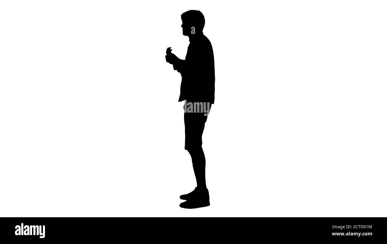 Silhouette Smiling young man playing ukulele looking into the ca Stock Photo