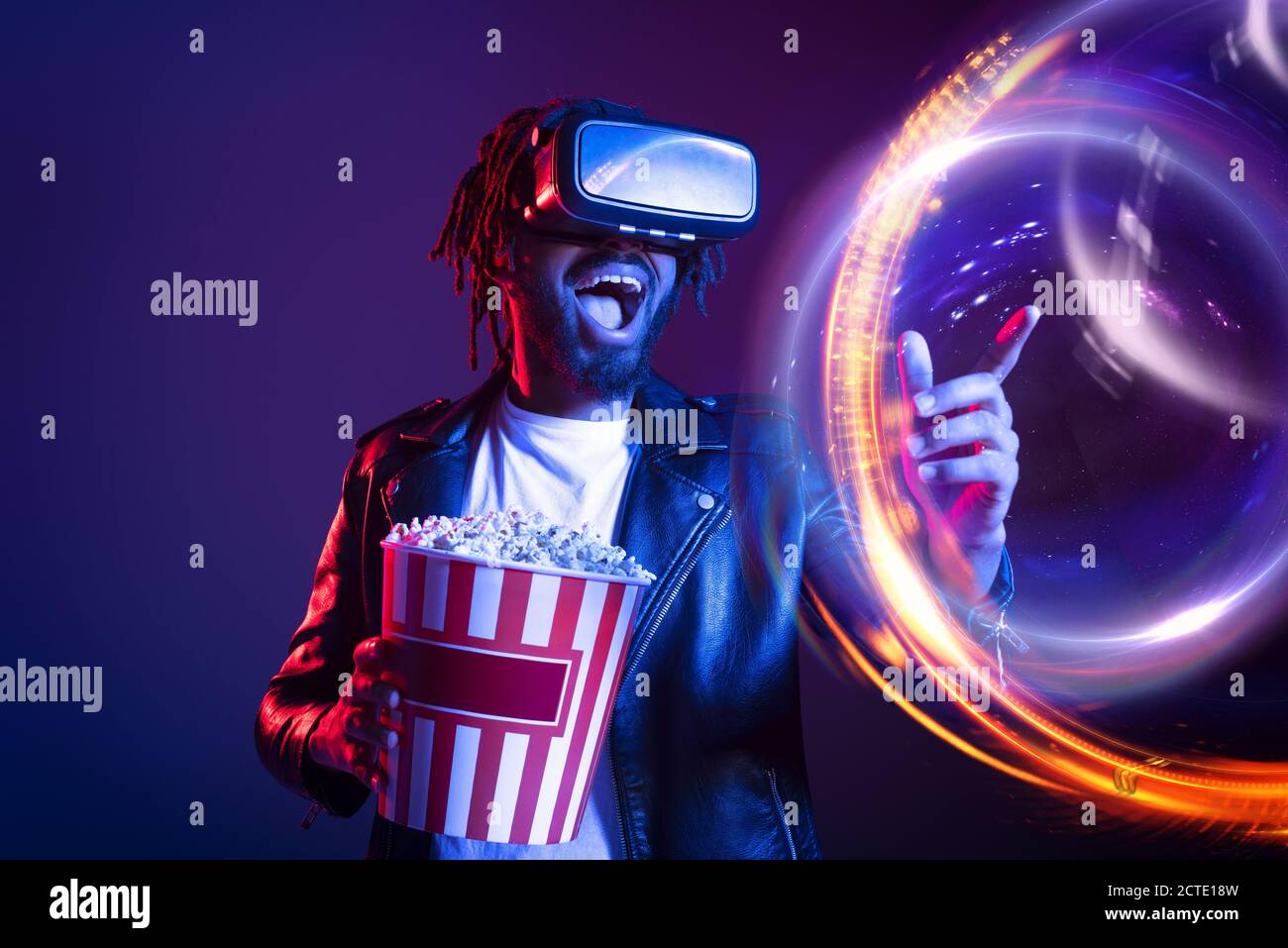 Man with VR glasses and popcorn watches a 3D film Stock Photo
