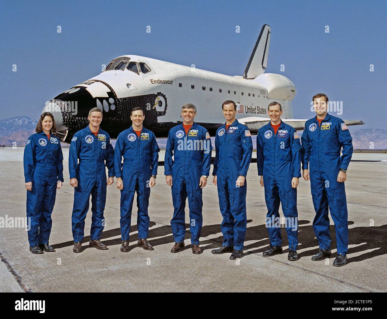 (16 Jan. 1992) --- These seven NASA astronauts are currently training for the first flight of the Space Shuttle Endeavour, seen in the background. Daniel C. Brandenstein, center, is mission commander; and Kevin P. Chilton, third from right, is pilot. Mission specialists are, left to right, Kathryn Thornton, Bruce Melnick, Pierre Thout, Thomas Akers and Richard Hieb. Stock Photo