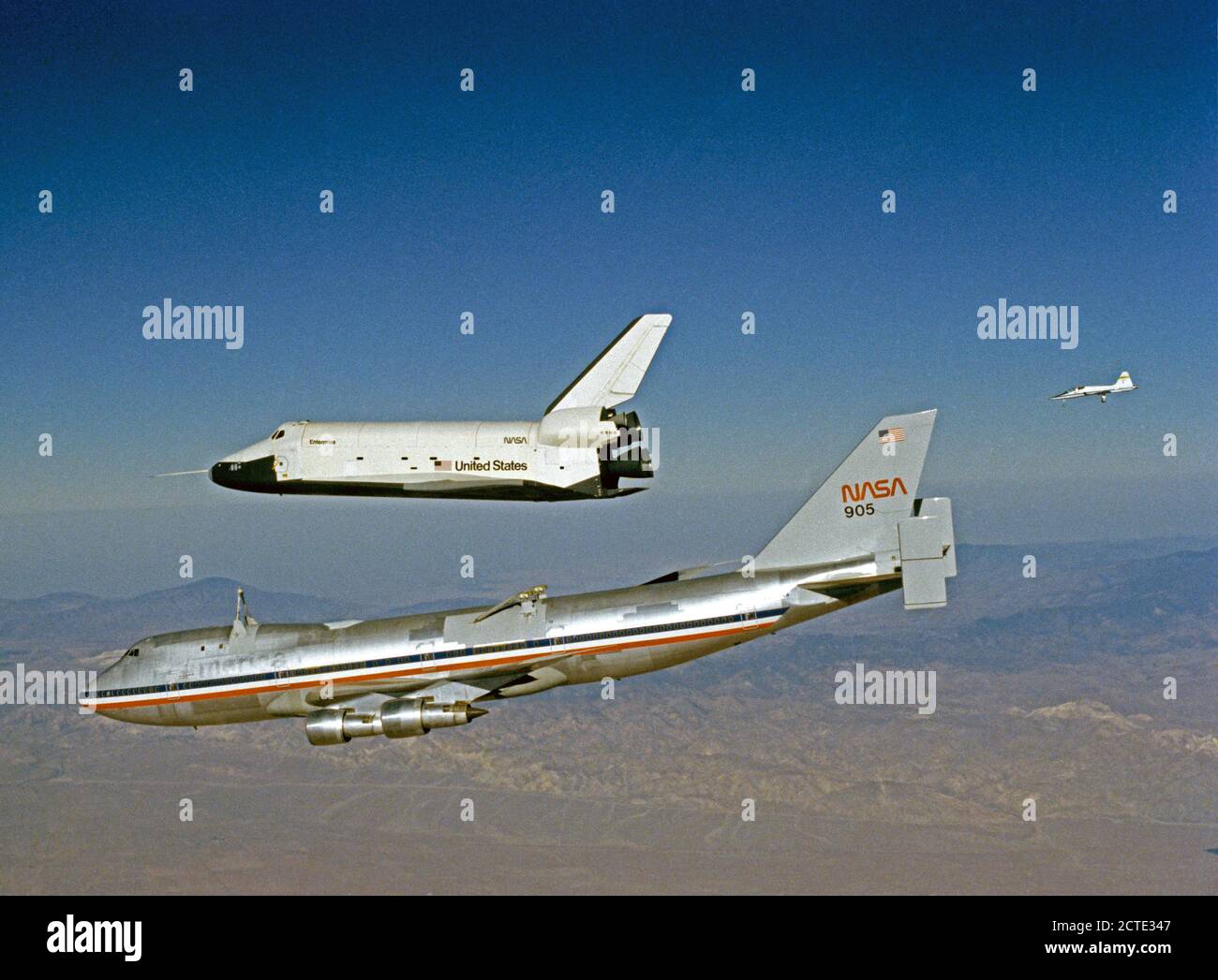 (12 Oct. 1977) --- The Orbiter 101 'Enterprise' separates from the NASA 747 carrier aircraft to begin its first 'tailcone-off' unpowered flight over desert and mountains of Southern California. A T-38 chase plane follows in right background. This was the fourth in a series of five piloted free flights. Stock Photo