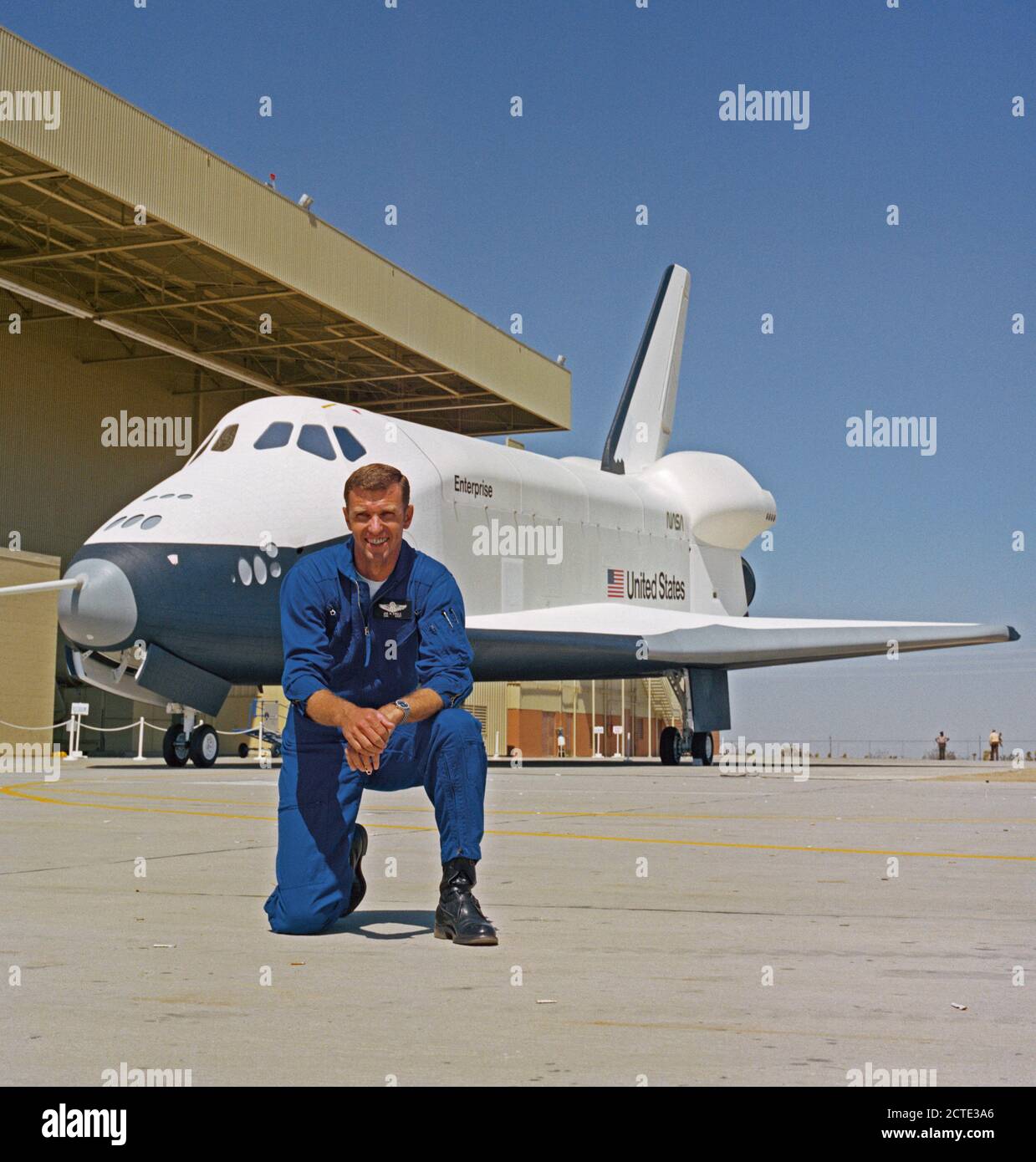 (17 Sept 1976) - - - Astronaut Joe H. Engle, commander of the second crew for the Space Shuttle Approach and Landing Tests (ALT), is photographed at the Rockwell International Space Division?s Orbiter assembly facility at Palmdale, California on the day of the roll out of the Space Shuttle Orbiter 101 ?Enterprise? spacecraft.  The DC-size airplane-like Orbiter 101 is in the background. Stock Photo