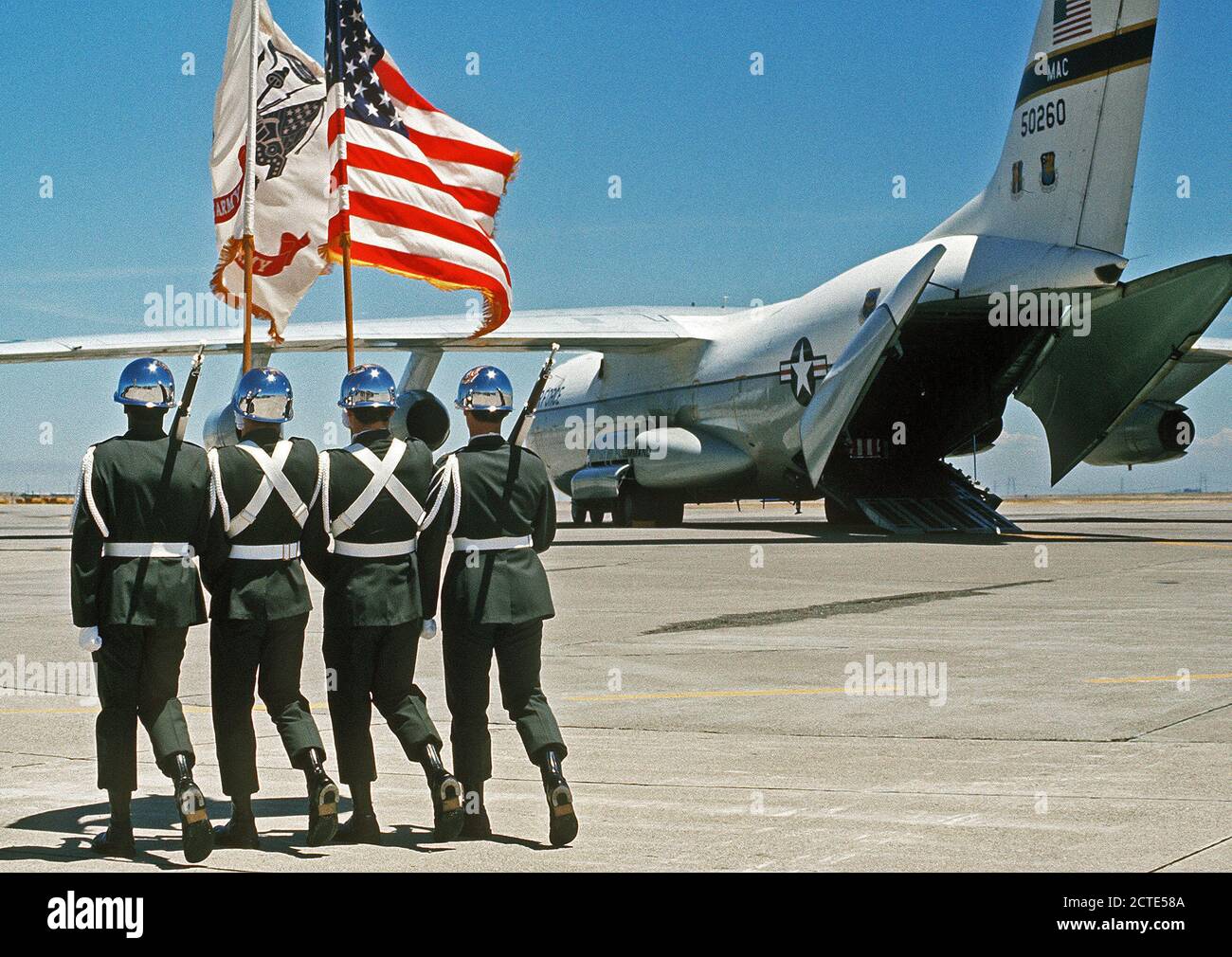 1977 - An Army color guard marches out to meet a C-141 Starlifter aircraft carrying the caskets of three U.S. Army soldiers who were killed in a helicopter crash in Korea on July 14, 1977. Stock Photo