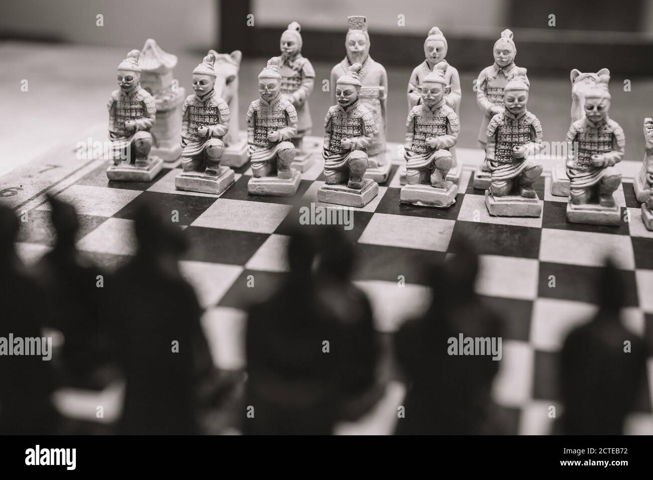 Grayscale closeup shot of a chessboard with human figurines Stock Photo