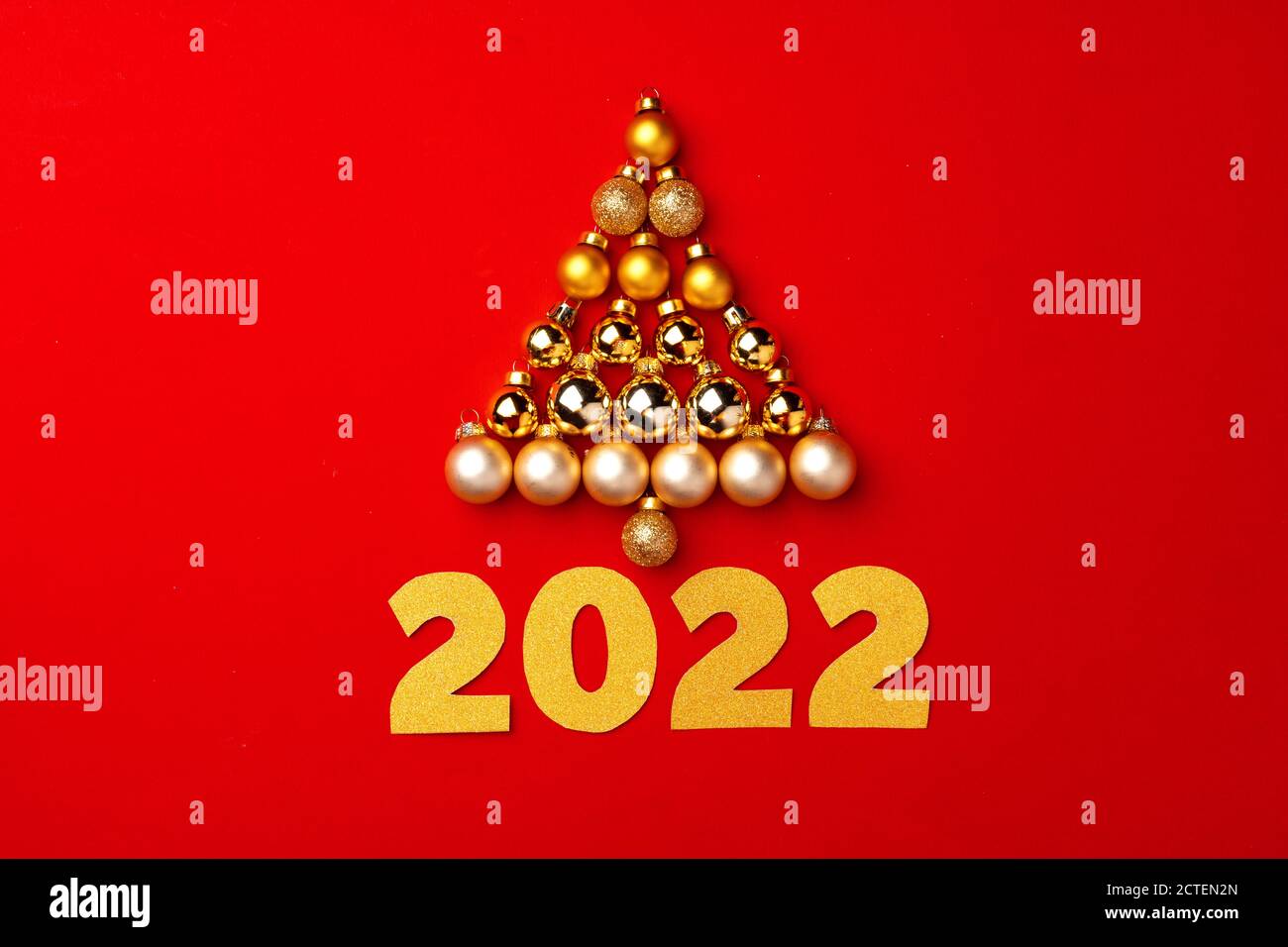 Christmas tree made of gold baubles on red background Stock Photo - Alamy