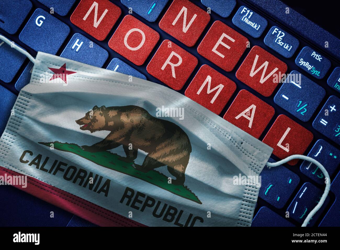 COVID-19 coronavirus new normal concept in the US state of California as shown by Californian flag on face mask with New Normal on laptop red alert ke Stock Photo