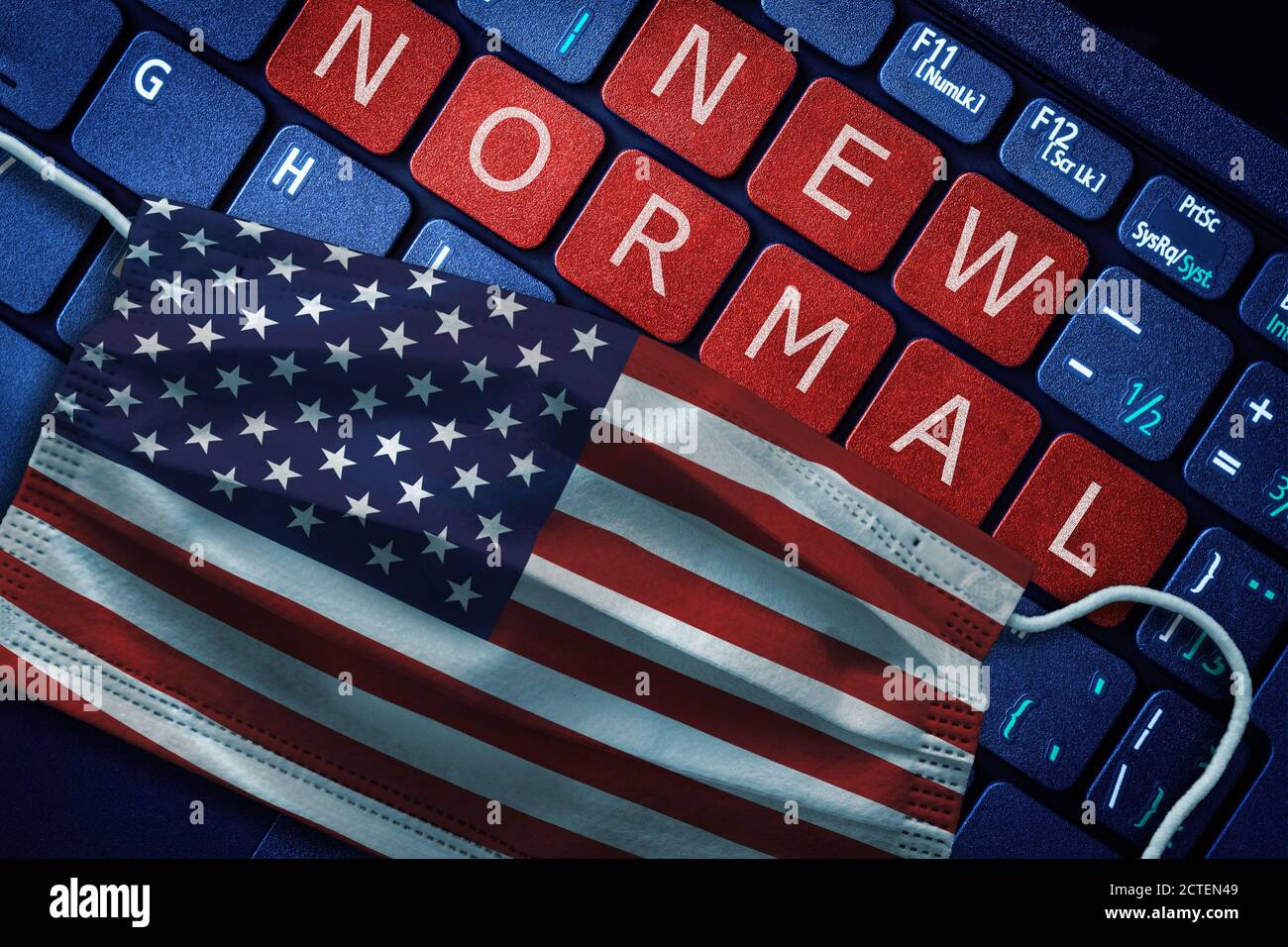 COVID-19 coronavirus new normal concept in United States as shown by US flag on face mask with New Normal on laptop red alert keyboard buttons. Stock Photo