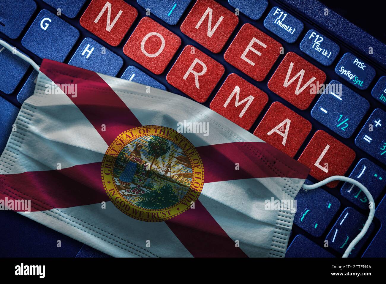 COVID-19 coronavirus new normal concept in the US state of Florida as shown by its state flag on face mask with New Normal on laptop red alert keyboar Stock Photo