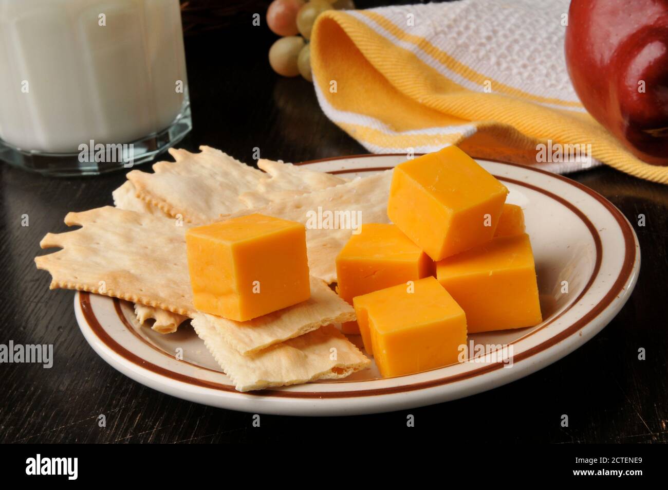 Gourmet flatbread crackers with aged cheddar cheese, an apple and milk